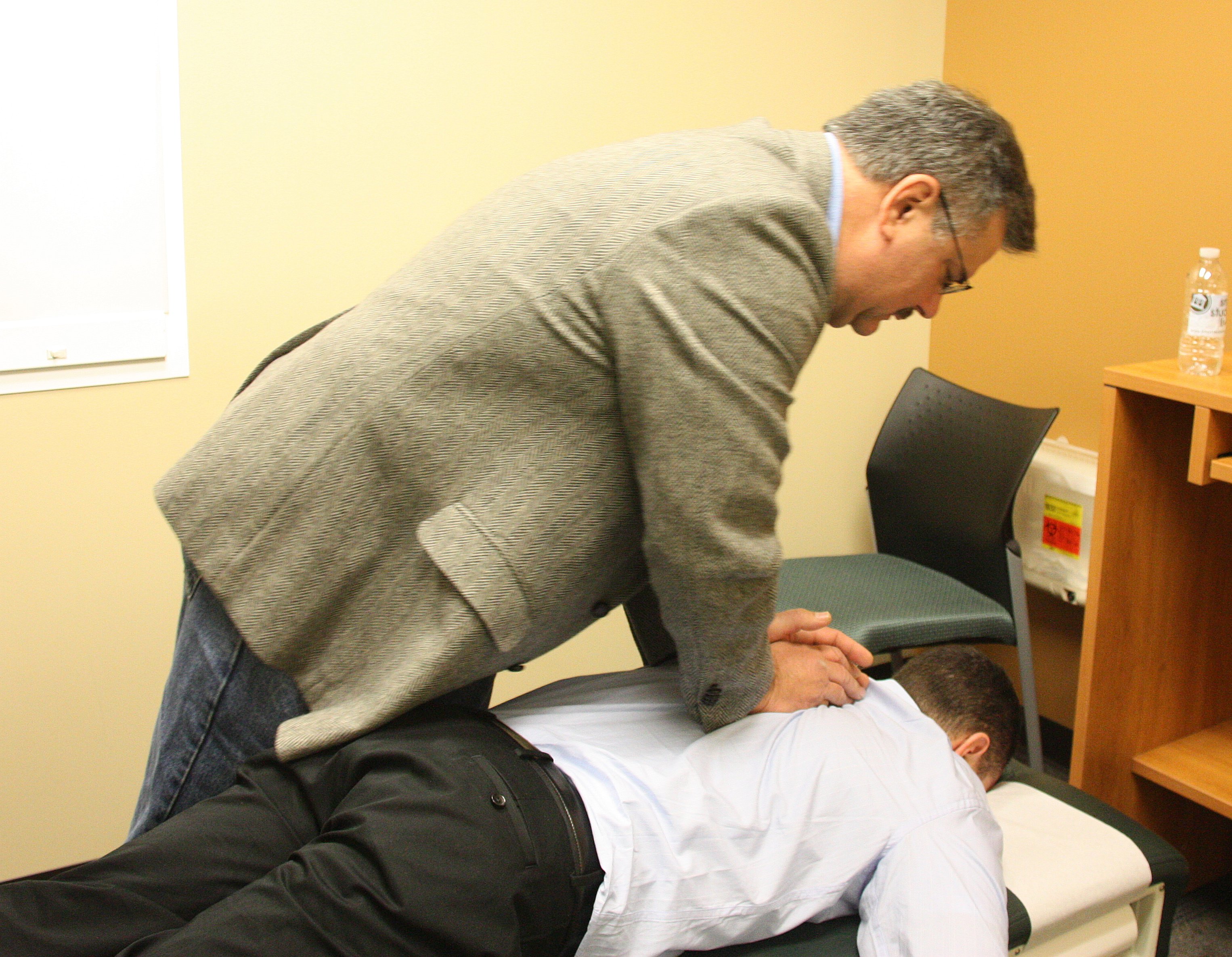Chiropractic adjustment being performed on a patient lying on a chiropractic table
